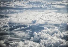 Blick auf blauen Himmel und flauschige Wolken aus einem Flugzeugfenster foto