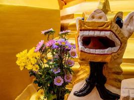 ein Blumenstrauß für die Anbetung und eine Löwenstatue aus Burma am Fuß der Pagode foto