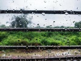 Nahaufnahme von Wassertröpfchen auf dem Fenster eines fahrenden Zuges d foto