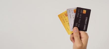 Hand hält drei Kreditkarten auf weißem Hintergrund. foto