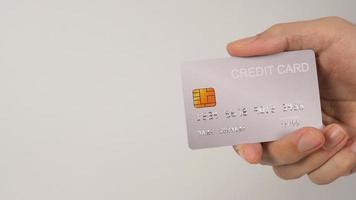 Hand hält silberne Kreditkarte auf weißem Hintergrund. foto