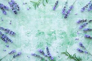 Lavendelblüten und Blätter kreativer Rahmen auf grünem Holzhintergrund foto