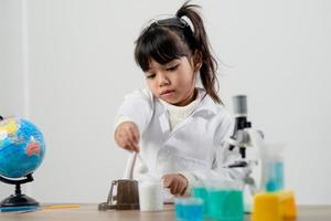 bildung, wissenschaft, chemie und kinderkonzept - kinder oder schüler mit reagenzglasexperimenten im schullabor foto