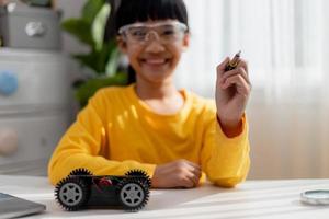 asia studenten lernen zu hause in der codierung von roboterautos und elektronischen platinenkabeln in stamm-, dampf-, mathematik-ingenieurwissenschaften-technologie-computercode im robotikkonzept für kinder. foto