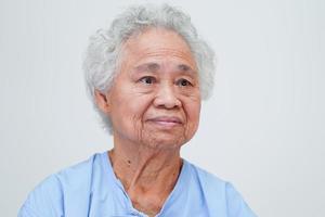 asiatische ältere seniorin, patientin, sitzend und lächelndes gesicht mit glücklichem auf dem bett im krankenhaus. foto