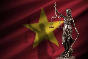 Vietnam-Flagge mit Statue der Justitia und Gerichtswaage im dunklen Raum. Konzept von Urteil und Bestrafung foto