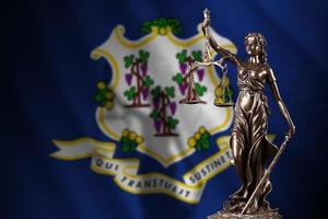 Connecticut US-Staatsflagge mit Statue der Justitia und Gerichtswaage im dunklen Raum. Konzept von Urteil und Bestrafung foto
