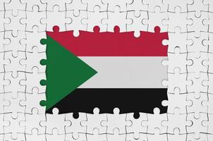 Sudan-Flagge im Rahmen aus weißen Puzzleteilen mit fehlendem Mittelteil foto
