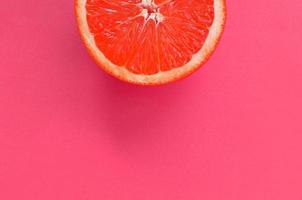 Draufsicht auf eine Grapefruitscheibe auf hellem Hintergrund in rosa Farbe. ein gesättigtes Zitrustexturbild foto