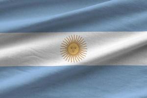 argentinische flagge mit großen falten, die dicht unter dem studiolicht im innenbereich wehen. die offiziellen symbole und farben im banner foto