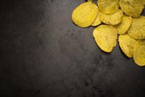 Kartoffelchips auf dunklem Hintergrund foto