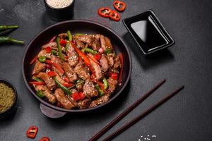 Köstliches asiatisches Teriyaki-Fleisch mit roter und grüner Paprika foto