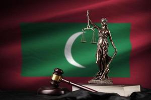 Malediven-Flagge mit Statue der Justitia, Verfassung und Richterhammer auf schwarzem Vorhang. Begriff von Urteil und Schuld foto