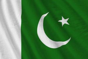 pakistan-flagge mit großen falten, die nah oben unter dem studiolicht drinnen winken. die offiziellen symbole und farben im banner foto