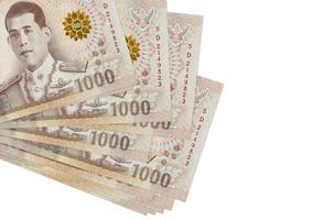 1000 thailändische baht-scheine liegen in kleinen bündeln oder packungen isoliert auf weiß. modell mit kopierraum. Geschäft und Geldwechsel foto