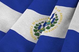 el salvador flagge mit großen falten, die nah oben unter dem studiolicht drinnen winken. die offiziellen symbole und farben im banner foto