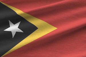 timor-leste-flagge mit großen falten, die dicht unter dem studiolicht im innenbereich wehen. die offiziellen symbole und farben im banner foto