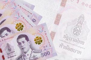 500 thailändische Baht-Scheine liegen im Stapel auf dem Hintergrund einer großen halbtransparenten Banknote. abstrakter betriebswirtschaftlicher hintergrund foto