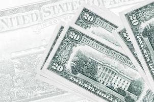 20 US-Dollar-Scheine liegen im Stapel auf dem Hintergrund einer großen halbtransparenten Banknote. abstrakte Darstellung der Landeswährung foto