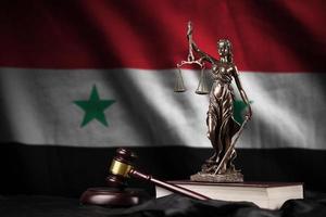 Syrien-Flagge mit Statue der Justitia, Verfassung und Richterhammer auf schwarzem Vorhang. Begriff von Urteil und Schuld foto