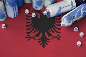 Albanien-Flagge und wenige gebrauchte Aerosol-Sprühdosen für Graffiti-Malerei. Street-Art-Kulturkonzept foto