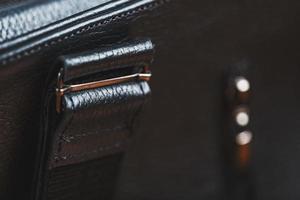 Details und Elemente der Tasche sind handgefertigt aus schwarzem Leder, Nahaufnahmen, Makroschlösser. foto