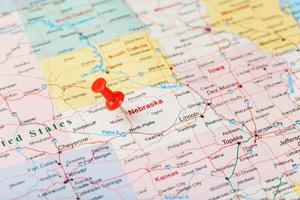 rote schreibnadel auf einer karte der usa, nebraska und der hauptstadt lincoln. Nahaufnahme der Karte von Nebraska mit rotem Reißzwecken foto
