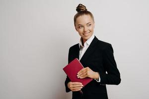 Zufriedene Geschäftsfrau im formellen Outfit mit Notizbuch foto