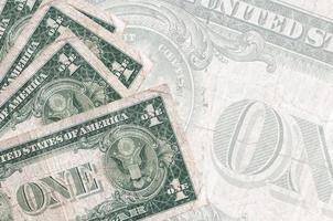 1 us-dollarscheine liegen im stapel auf dem hintergrund einer großen halbtransparenten banknote. abstrakter betriebswirtschaftlicher hintergrund foto