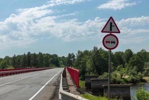 zwei Schilder an der Straße vor der Brücke foto