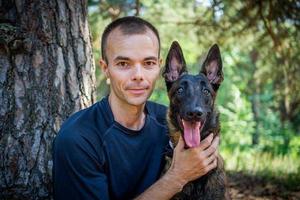 Der junge kaukasische Hipster verbringt an einem sonnigen Sommertag Zeit mit seinem Hund im Park. das Konzept eines Haustieres als Familienmitglied foto