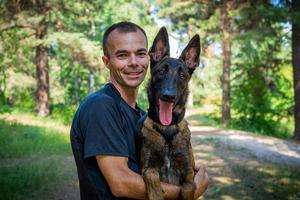 Der junge kaukasische Hipster verbringt an einem sonnigen Sommertag Zeit mit seinem Hund im Park. das Konzept eines Haustieres als Familienmitglied foto