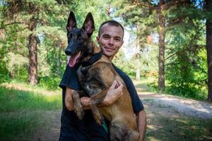 Der junge kaukasische Hipster verbringt an einem sonnigen Sommertag Zeit mit seinem Hund im Park. das Konzept eines Haustieres als Familienmitglied foto