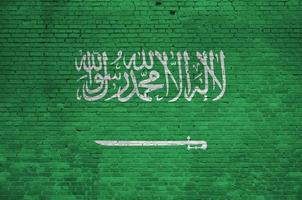 Saudi-Arabien-Flagge in Lackfarben auf alter Ziegelwand dargestellt. strukturiertes banner auf großem backsteinmauermauerwerkhintergrund foto
