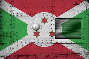 burundi-flagge auf der seite des militärischen gepanzerten panzers in der nähe abgebildet. konzeptioneller hintergrund der armee foto