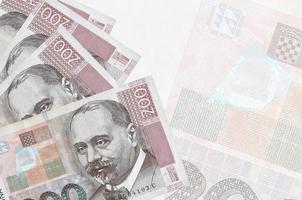 200 kroatische Kuna-Scheine liegen im Stapel auf dem Hintergrund einer großen halbtransparenten Banknote. abstrakter betriebswirtschaftlicher hintergrund foto