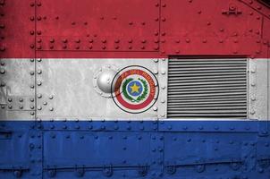 paraguay-flagge auf seitenteil des militärischen gepanzerten panzers in der nähe abgebildet. konzeptioneller hintergrund der armee foto