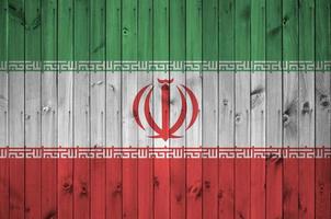 iranische flagge in hellen farben auf alter holzwand dargestellt. strukturierte Fahne auf rauem Hintergrund foto