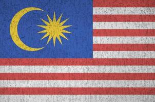 malaysia-flagge in hellen farben auf alter reliefputzwand dargestellt. strukturierte Fahne auf rauem Hintergrund foto