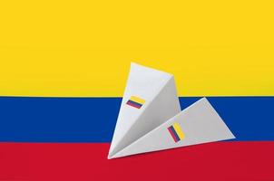 Kolumbien-Flagge auf Papier-Origami-Flugzeug dargestellt. handgemachtes kunstkonzept foto