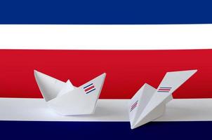costa rica flagge auf papier origami flugzeug und boot dargestellt. handgemachtes kunstkonzept foto