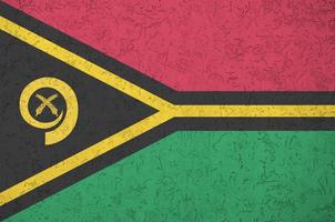 vanuatu-flagge in hellen farben auf alter reliefputzwand dargestellt. strukturierte Fahne auf rauem Hintergrund foto