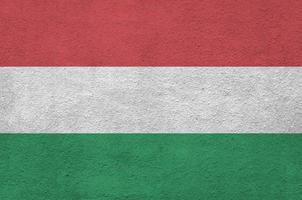 ungarische flagge in hellen farben auf alter reliefputzwand dargestellt. strukturierte Fahne auf rauem Hintergrund foto