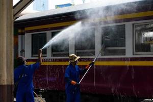 bangkok, thailand - 24. september ein reiniger reinigt einen zug am bahnhof hua lamphong am 24. september 2022 in bangkok, thailand. foto