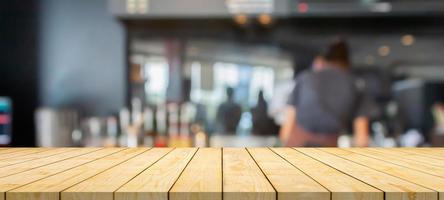 leere hölzerne tischplatte mit café-restaurant-zählerunschärfehintergrund foto