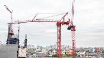 blick auf die baustelle und rote krane für den bau moderner wohngebiete, baukonzept für die entwicklungsstadt. foto