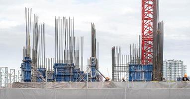 blick auf die baustelle und rote krane für den bau moderner wohngebiete, baukonzept für die entwicklungsstadt. foto