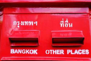 Schließen Sie herauf roten thailändischen Briefkasten. Übersetzungstexte oben sind Bangkok und andere Orte. foto