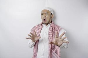 ein Porträt eines schockierten asiatischen muslimischen Mannes, der durch einen weißen Hintergrund isoliert ist foto