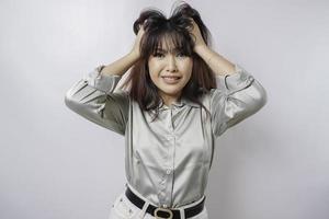 ein porträt einer asiatischen frau, die ein salbeigrünes hemd trägt, das durch weißen hintergrund isoliert ist, sieht deprimiert aus foto
